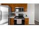 Modern kitchen featuring stainless steel appliances, sleek cooktop, and wood cabinetry with ample storage space at 389 Vinewood N Dr, Brownsburg, IN 46112