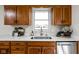 Well-lit kitchen showcasing light countertops, wood cabinets, and stainless steel dishwasher at 389 Vinewood N Dr, Brownsburg, IN 46112