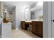 A well-lit bathroom with tile flooring, dual vanities, and a shower-tub combination at 3965 Andretti Dr, Zionsville, IN 46077