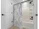 A bathroom with white wainscoting, decorative tile, a shower-tub, and dark plumbing fixtures at 3965 Andretti Dr, Zionsville, IN 46077