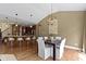 Bright dining room with hardwood floors and a modern chandelier adjacent to the kitchen's breakfast bar at 3965 Andretti Dr, Zionsville, IN 46077