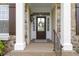 Inviting front porch with stone accents, decorative wreath, and classic architectural details at 3965 Andretti Dr, Zionsville, IN 46077