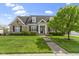 Charming stone home featuring a manicured lawn, lush landscaping, and inviting front entrance at 3965 Andretti Dr, Zionsville, IN 46077