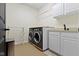 A tidy laundry room with modern washer/dryer, storage cabinets, and a sink at 3965 Andretti Dr, Zionsville, IN 46077