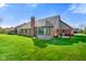 Expansive backyard featuring well-maintained lawn, patio area, and brick home with sunroom at 4316 Moss Ridge Cir, Indianapolis, IN 46237