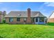 The backyard features a well-manicured lawn and a brick home with a cozy sunroom addition at 4316 Moss Ridge Cir, Indianapolis, IN 46237