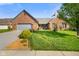 Charming brick home featuring a well-manicured lawn, inviting curb appeal, and a two-car attached garage at 4316 Moss Ridge Cir, Indianapolis, IN 46237