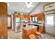 Kitchen boasts wooden cabinets, appliances, kitchen island, and dining table under vaulted ceiling at 4316 Moss Ridge Cir, Indianapolis, IN 46237