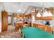 Kitchen features wooden cabinets, appliances, kitchen island, and dining table under vaulted ceiling at 4316 Moss Ridge Cir, Indianapolis, IN 46237