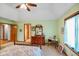 Bright bedroom featuring a ceiling fan, green walls, carpeted floors, and wood furnishings at 4316 Moss Ridge Cir, Indianapolis, IN 46237