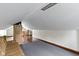 An attic room features gray carpeting, hardwood flooring, and a partial couch at 46 N Kitley Ave, Indianapolis, IN 46219