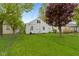 Large backyard features well-manicured lawn, trees, and fenced perimeter at 46 N Kitley Ave, Indianapolis, IN 46219