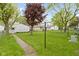 Manicured backyard with green grass, trees, and a white detached garage at 46 N Kitley Ave, Indianapolis, IN 46219