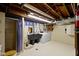 Unfinished basement featuring a utility sink, washer, dryer, and open ceiling at 46 N Kitley Ave, Indianapolis, IN 46219