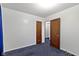 A simple bedroom features blue carpeting and two doors at 46 N Kitley Ave, Indianapolis, IN 46219