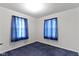 A bedroom features blue carpeting and natural lighting through two windows at 46 N Kitley Ave, Indianapolis, IN 46219