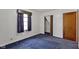 A simple bedroom features blue carpeting, a closet, and a window at 46 N Kitley Ave, Indianapolis, IN 46219