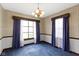 Bright dining room with natural lighting, vintage chandelier and blue carpeting at 46 N Kitley Ave, Indianapolis, IN 46219