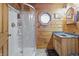 Bathroom featuring octagon window, wood walls, double vanity, and a walk-in shower at 4840 N Templin Rd, Martinsville, IN 46151