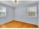 Empty bedroom features hardwood floors, natural light, and modern lighting fixture at 4914 Indianola Ave, Indianapolis, IN 46205