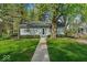 Charming single-story home features a well-manicured front yard with lush lawn and mature trees at 4914 Indianola Ave, Indianapolis, IN 46205