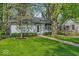 Charming single-story home features a well-manicured front yard with lush lawn and mature trees at 4914 Indianola Ave, Indianapolis, IN 46205