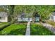 Charming single-story home features a well-manicured front yard with lush lawn and mature trees at 4914 Indianola Ave, Indianapolis, IN 46205