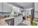 Bright kitchen with stainless steel appliances, granite countertops, white cabinets, and modern lighting at 4914 Indianola Ave, Indianapolis, IN 46205