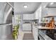 Bright kitchen with stainless steel appliances, granite countertops, white cabinets, and modern lighting at 4914 Indianola Ave, Indianapolis, IN 46205