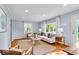 Bright living room featuring hardwood floors, a neutral sofa, stylish decor and lots of natural light at 4914 Indianola Ave, Indianapolis, IN 46205