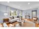 Bright living room featuring hardwood floors, a neutral sofa, stylish decor and lots of natural light at 4914 Indianola Ave, Indianapolis, IN 46205