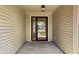 A covered front porch with concrete floor and a glass front door with side window at 504 Countryside Dr, Lebanon, IN 46052