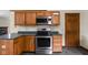 Kitchen featuring wood cabinetry, stainless appliances, and tile floors at 504 Countryside Dr, Lebanon, IN 46052