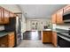 Kitchen featuring wood cabinetry, tiled floors, stainless steel refrigerator, and backyard views at 504 Countryside Dr, Lebanon, IN 46052