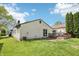 Cozy backyard featuring a wood deck with patio seating, surrounded by lush green grass and mature trees at 5323 Shefford Ct, Indianapolis, IN 46254