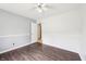 Bright bedroom featuring dark wood-look floors, fresh paint, and an open doorway at 5323 Shefford Ct, Indianapolis, IN 46254
