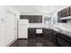 Features dark cabinets, black floors, white appliances and tile backsplash at 5323 Shefford Ct, Indianapolis, IN 46254