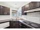 Features a stainless steel sink and tiled backsplash with dark cabinetry at 5323 Shefford Ct, Indianapolis, IN 46254
