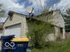 Side view of a home with a two-car garage and minimal landscaping at 5327 Traditions Dr, Indianapolis, IN 46235