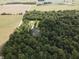 Aerial view of wooded acreage surrounding a single Gathering home and multiple storage buildings at 5607 E 500 N, Greenfield, IN 46140