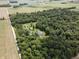 Aerial view of large wooded acreage with the home and several storage buildings at 5607 E 500 N, Greenfield, IN 46140