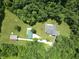 Aerial view of wooded acreage with the home, a driveway, and multiple storage buildings at 5607 E 500 N, Greenfield, IN 46140