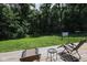 Relaxing backyard view with a wooden deck and seating, surrounded by mature trees and lush greenery at 5607 E 500 N, Greenfield, IN 46140