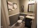 Stylish half bath features dark vanity, neutral walls with art, framed mirror, and tile floors at 5607 E 500 N, Greenfield, IN 46140