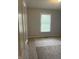 Bedroom features a light gray carpet and a window offering an exterior view, providing natural light at 5607 E 500 N, Greenfield, IN 46140