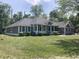 Beautifully landscaped front yard with a well-maintained house featuring dark siding at 5607 E 500 N, Greenfield, IN 46140