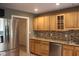 Bright eat-in kitchen featuring a stainless steel refrigerator, natural wood cabinetry, and granite countertops at 5607 E 500 N, Greenfield, IN 46140