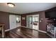 Open-concept living room featuring sliding glass doors to the sunroom, hardwood floors, and modern décor at 5607 E 500 N, Greenfield, IN 46140