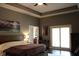 Spacious main bedroom featuring tray ceilings, a ceiling fan, and access to an ensuite bath and private balcony at 5607 E 500 N, Greenfield, IN 46140