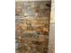This shower features beautiful earth-tone stonework, pebble flooring, and a modern shower head at 5607 E 500 N, Greenfield, IN 46140